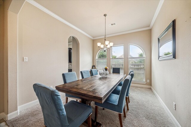 dining space featuring light carpet, arched walkways, visible vents, an inviting chandelier, and crown molding