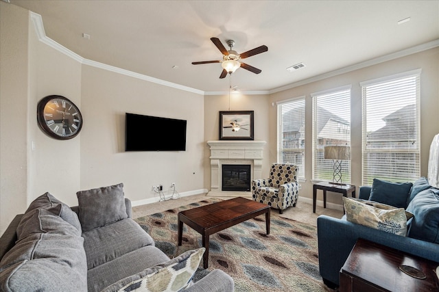 living room with carpet, visible vents, a ceiling fan, ornamental molding, and a glass covered fireplace