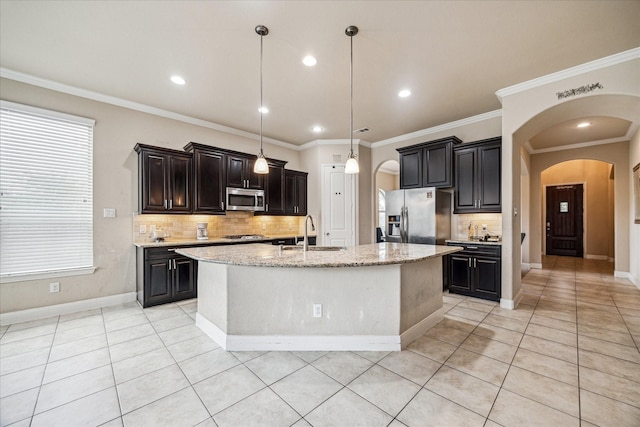 kitchen with light tile patterned floors, arched walkways, a sink, and appliances with stainless steel finishes