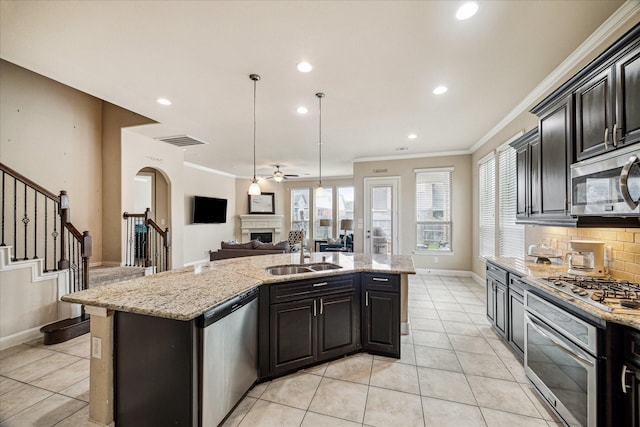 kitchen featuring a sink, ceiling fan, a fireplace, appliances with stainless steel finishes, and visible vents