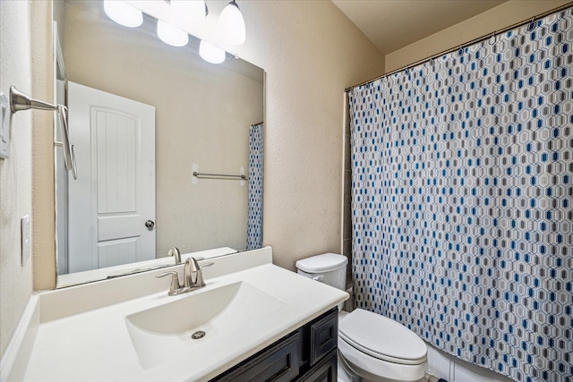 full bathroom featuring toilet, a textured wall, vanity, and curtained shower