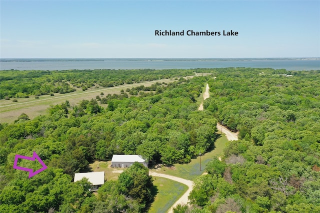 birds eye view of property featuring a view of trees and a water view