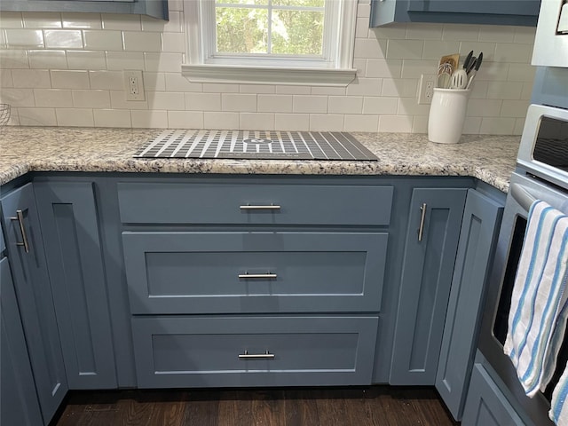 details featuring stainless steel oven, black electric cooktop, dark wood-style flooring, and tasteful backsplash