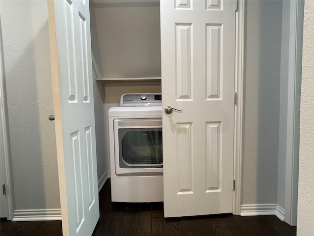 washroom with baseboards, washer / clothes dryer, dark wood-style floors, and laundry area