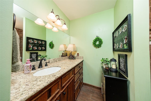 bathroom featuring baseboards, wood finished floors, and vanity