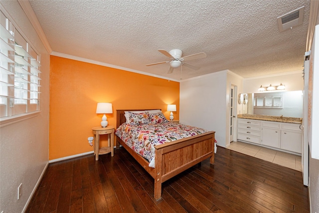 bedroom featuring hardwood / wood-style floors, baseboards, visible vents, and ornamental molding