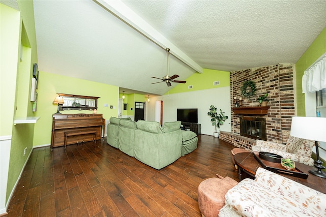 living room with a brick fireplace, a ceiling fan, hardwood / wood-style flooring, and lofted ceiling with beams