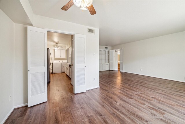 351 N Post Oak Ln Unit 617, Houston, TX 77024 - unfurnished bedroom featuring wood finished floors, visible vents, freestanding refrigerator, baseboards, and separate washer and dryer
