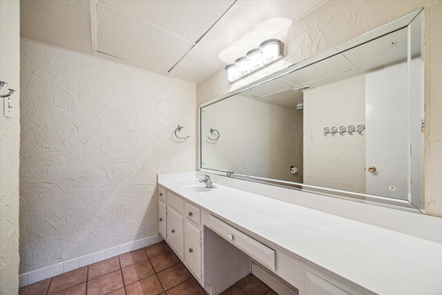 351 N Post Oak Ln Unit 617, Houston, TX 77024 - bathroom featuring baseboards, a textured wall, tile patterned flooring, and vanity