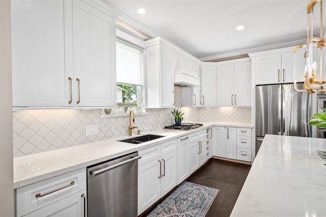 kitchen featuring white cabinetry, appliances with stainless steel finishes, a sink, and custom range hood