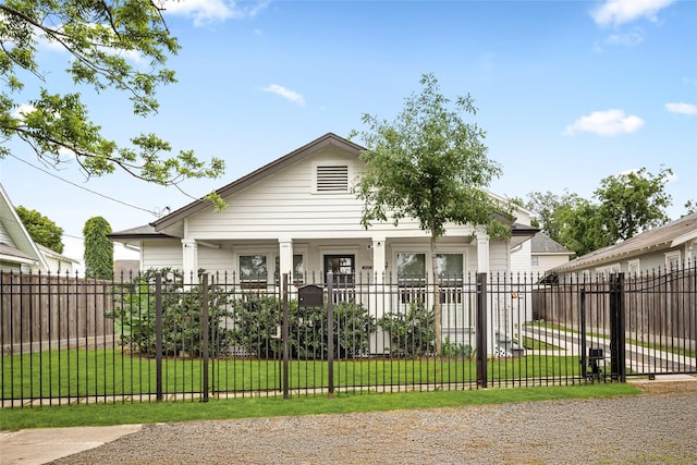 view of front of property featuring a porch, a fenced front yard, and a front yard