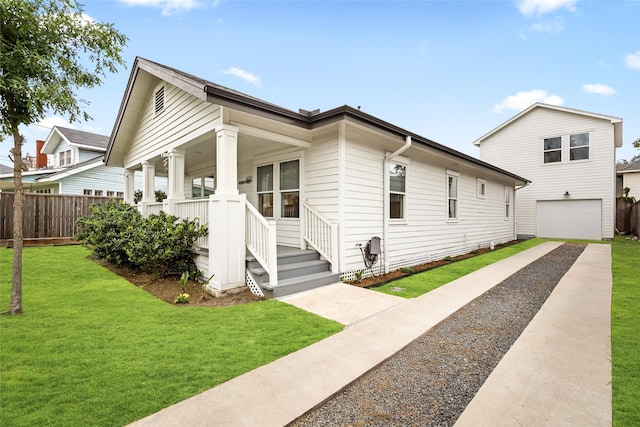 shotgun-style home with fence, an attached garage, a front lawn, a porch, and gravel driveway