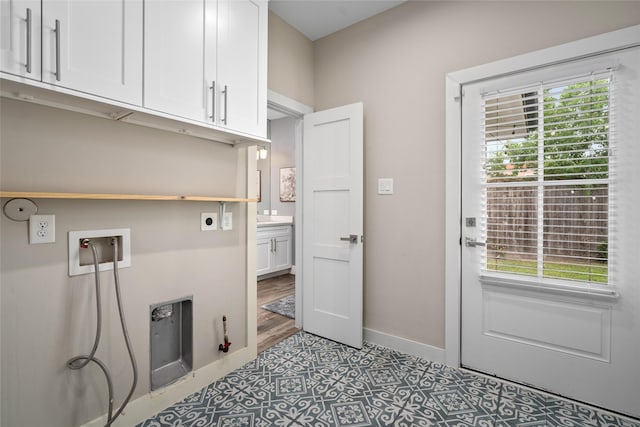laundry room with washer hookup, electric dryer hookup, cabinet space, and a wealth of natural light
