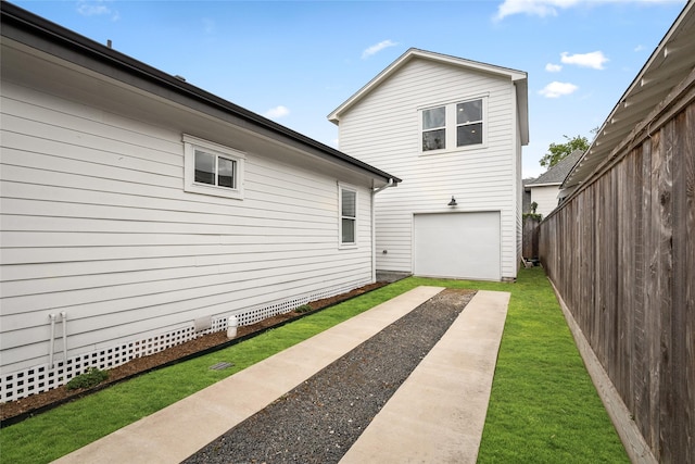 exterior space featuring a garage, fence, and driveway