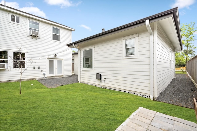 rear view of property with a lawn, fence, and cooling unit