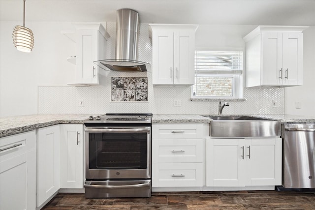kitchen featuring wall chimney range hood, appliances with stainless steel finishes, a sink, and white cabinetry
