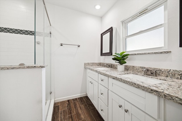full bath with recessed lighting, a sink, tiled shower, and wood finished floors