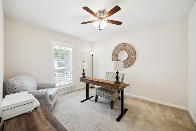 home office featuring baseboards, a ceiling fan, and light colored carpet