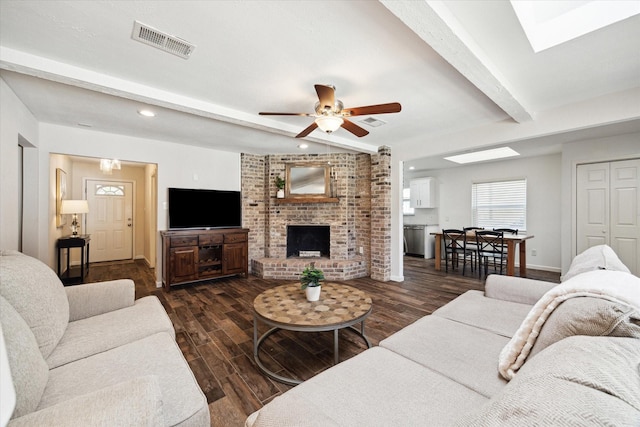 living area with baseboards, visible vents, dark wood-style floors, and beam ceiling
