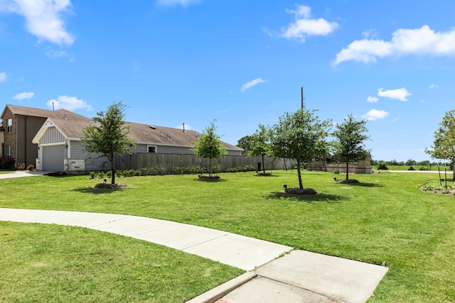 exterior space featuring a lawn, an attached garage, and fence