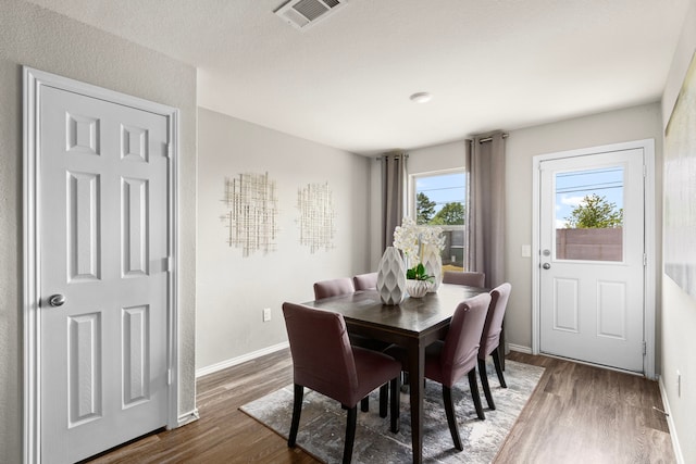dining room featuring visible vents, baseboards, and wood finished floors