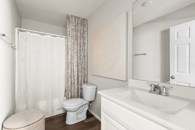 full bathroom with baseboards, wood finished floors, toilet, and vanity