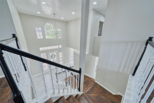 stairs with wood finished floors, baseboards, an inviting chandelier, and recessed lighting