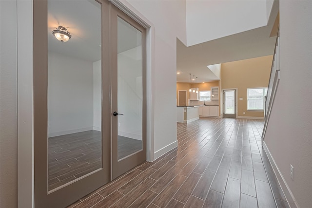 corridor featuring baseboards and wood tiled floor
