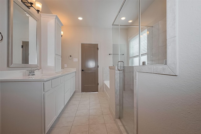 bathroom with a sink, double vanity, a stall shower, tile patterned flooring, and a garden tub