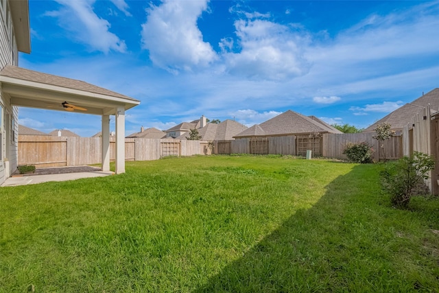 view of yard with ceiling fan, a fenced backyard, and a patio