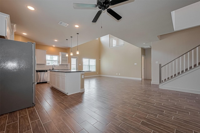 kitchen with tasteful backsplash, dark countertops, ceiling fan, baseboards, and appliances with stainless steel finishes