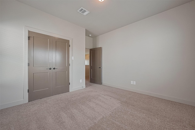 unfurnished bedroom with baseboards, carpet flooring, visible vents, and a closet