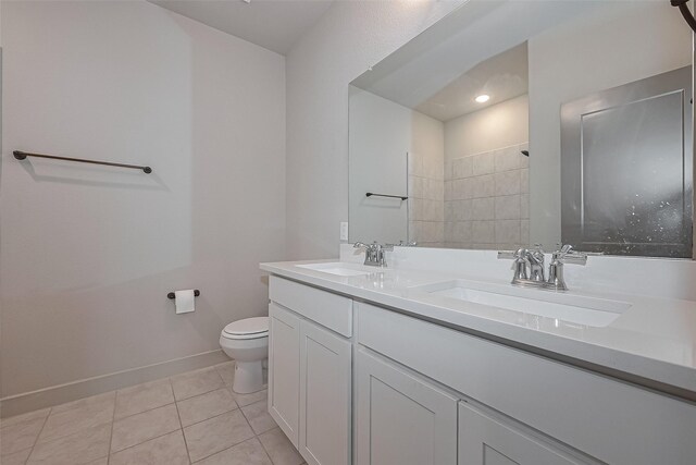 full bath featuring tile patterned floors, a sink, double vanity, and toilet