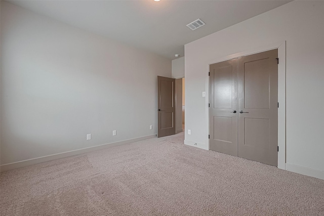 unfurnished bedroom featuring baseboards, a closet, visible vents, and carpet