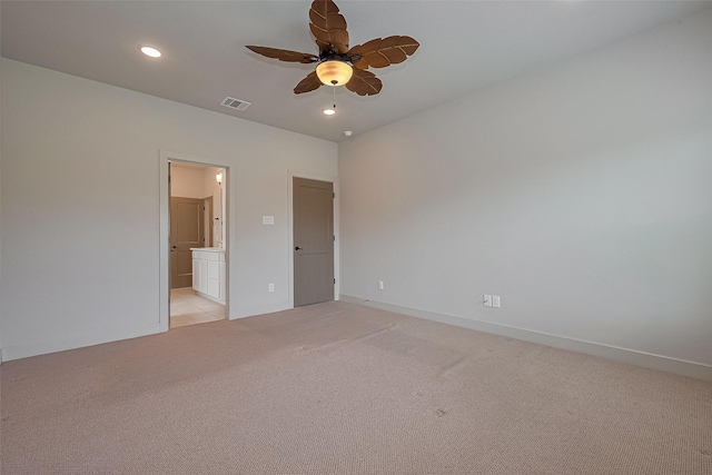 unfurnished bedroom featuring visible vents, baseboards, light carpet, and ensuite bathroom