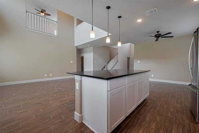 kitchen with visible vents, dark countertops, dark wood-style floors, and ceiling fan