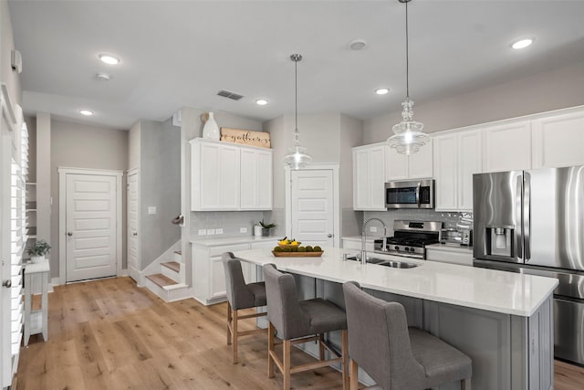 18611 Admiration Dr, Cypress, TX 77433 - kitchen featuring white cabinets, a kitchen breakfast bar, a sink, decorative backsplash, and appliances with stainless steel finishes