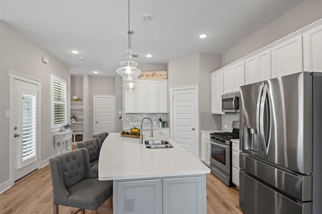 18611 Admiration Dr, Cypress, TX 77433 - kitchen with a sink, decorative backsplash, a breakfast bar, white cabinets, and appliances with stainless steel finishes