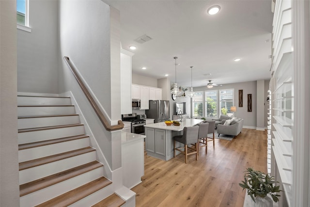 18611 Admiration Dr, Cypress, TX 77433 - kitchen with open floor plan, visible vents, appliances with stainless steel finishes, light countertops, and a breakfast bar area