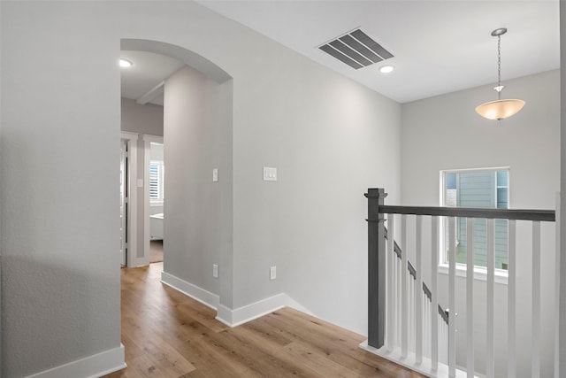 18611 Admiration Dr, Cypress, TX 77433 - hallway featuring wood finished floors, an upstairs landing, arched walkways, baseboards, and visible vents