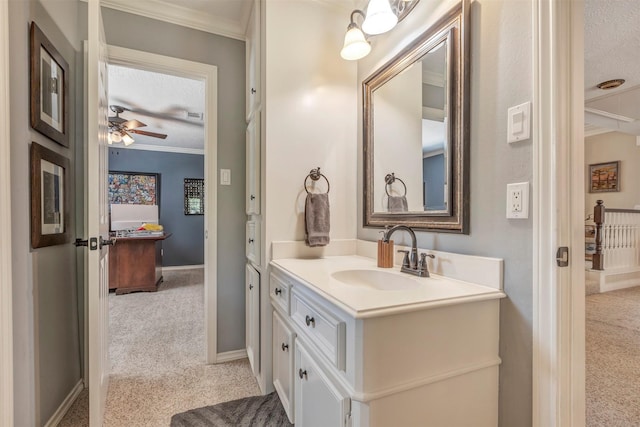 bathroom with crown molding, a ceiling fan, baseboards, and vanity