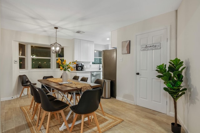 dining area with light wood-type flooring, baseboards, and visible vents