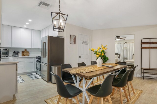 dining area featuring recessed lighting, a toaster, visible vents, light wood-type flooring, and ceiling fan with notable chandelier