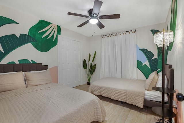 bedroom featuring a ceiling fan, wood finished floors, and a closet
