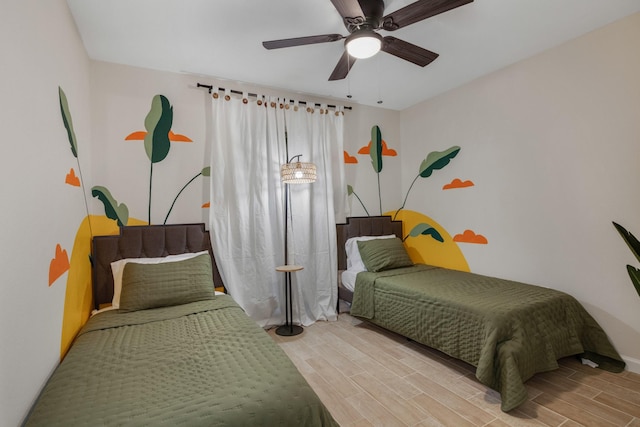 bedroom with wood finished floors, a ceiling fan, and baseboards