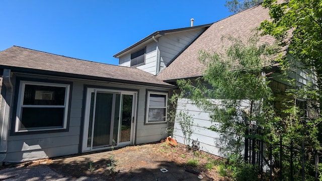 back of house with roof with shingles