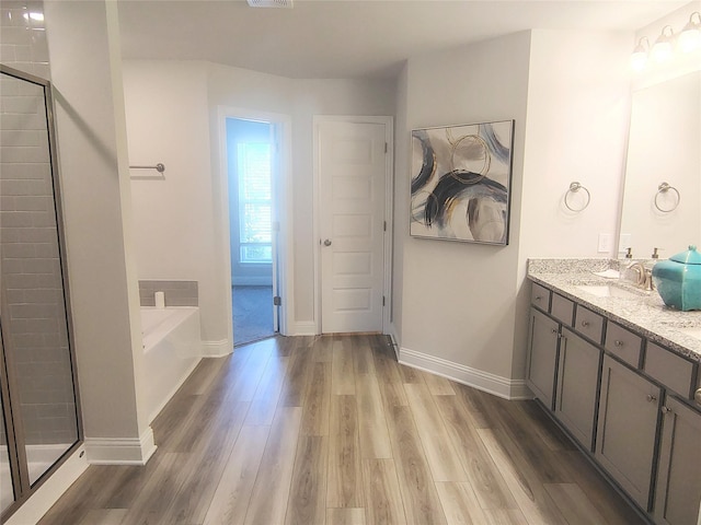 15 Gemstone Ct, Angleton, TX 77515 - bathroom with double vanity, a stall shower, a bath, a sink, and wood finished floors