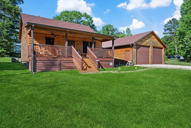 log cabin with stairway, a detached garage, a porch, a front yard, and roof with shingles