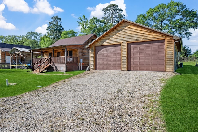 log-style house featuring a garage, a porch, a front yard, and log veneer siding