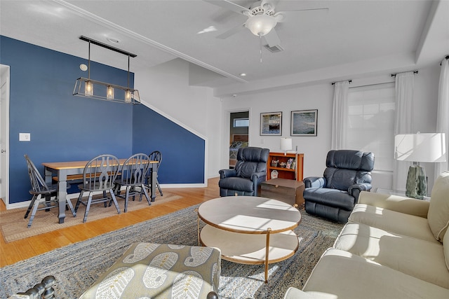 living room with baseboards, a ceiling fan, wood finished floors, and visible vents